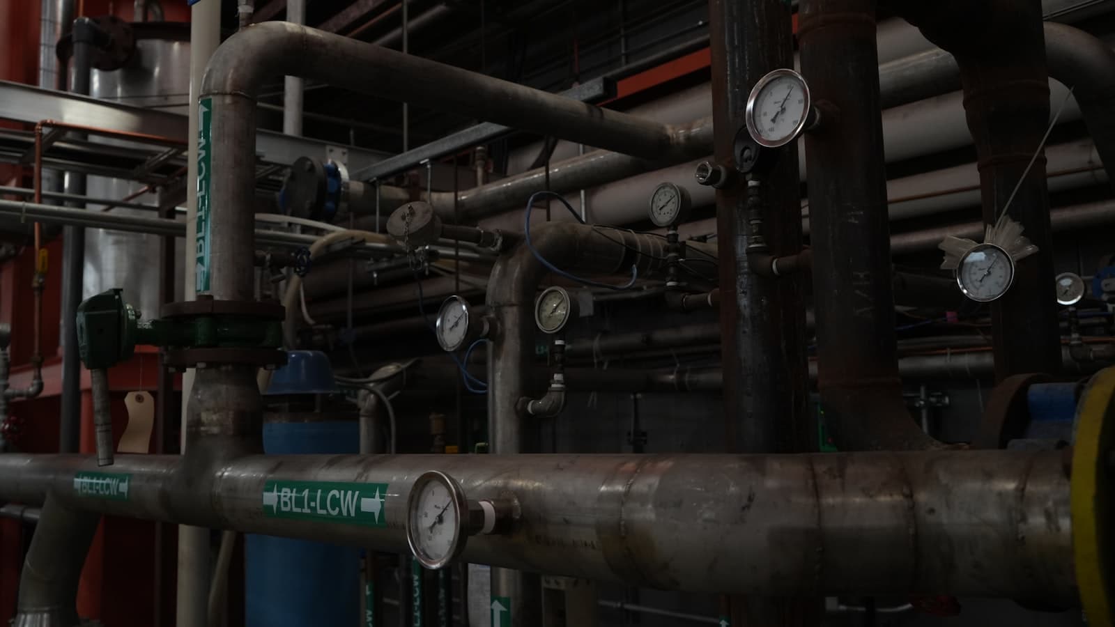 Network of industrial pipes, valves, and pressure gauges